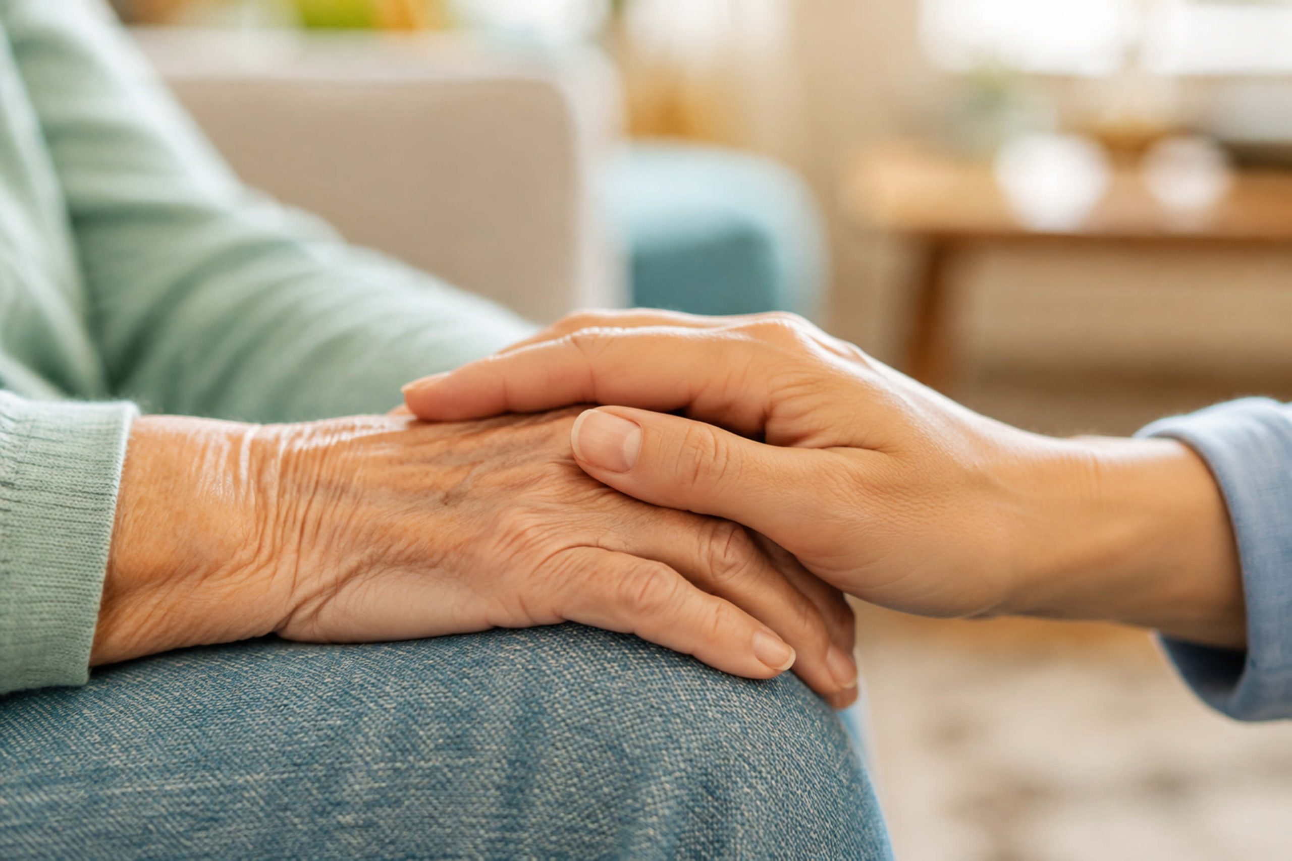 An older hand and a younger hand resting together